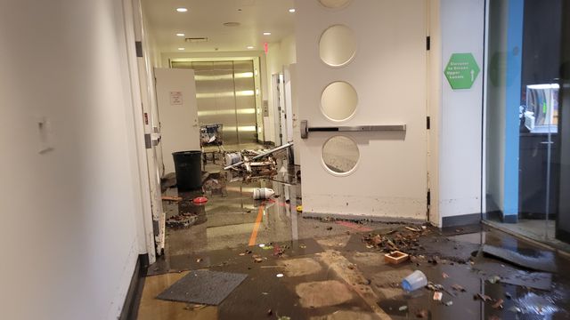 An elevator and hallway in a museum strewn with debris